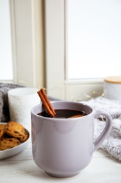 Photo of Cup of hot mulled wine on window sill. Winter drink