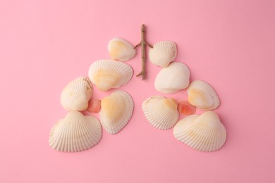 Human lungs made of seashells on pink background, flat lay
