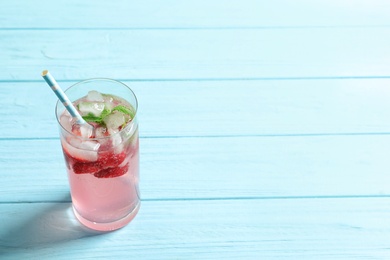 Natural lemonade with strawberries in glass on wooden table