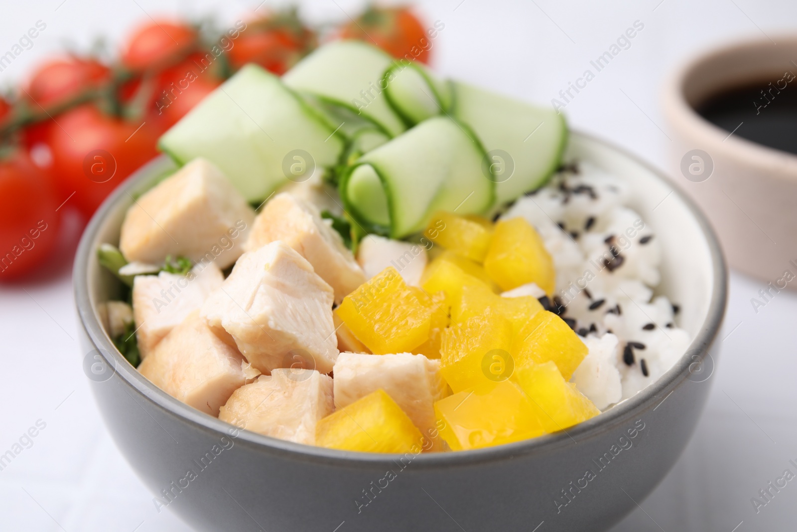 Photo of Delicious poke bowl with meat, rice and vegetables on white table, closeup