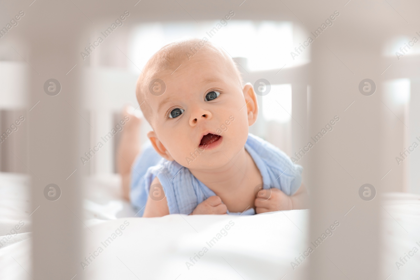 Photo of Cute little baby lying in crib at home