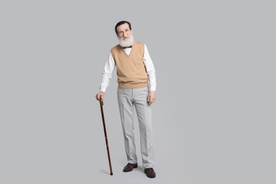 Photo of Senior man with walking cane on light gray background