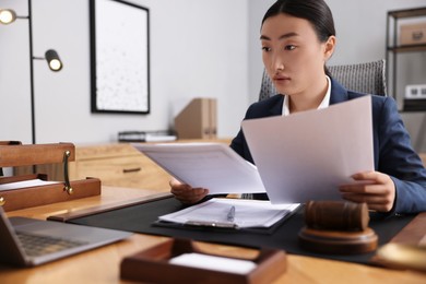 Notary reading documents at table in office