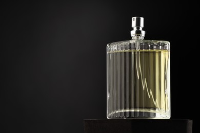 Luxury men`s perfume in bottle against dark background, space for text