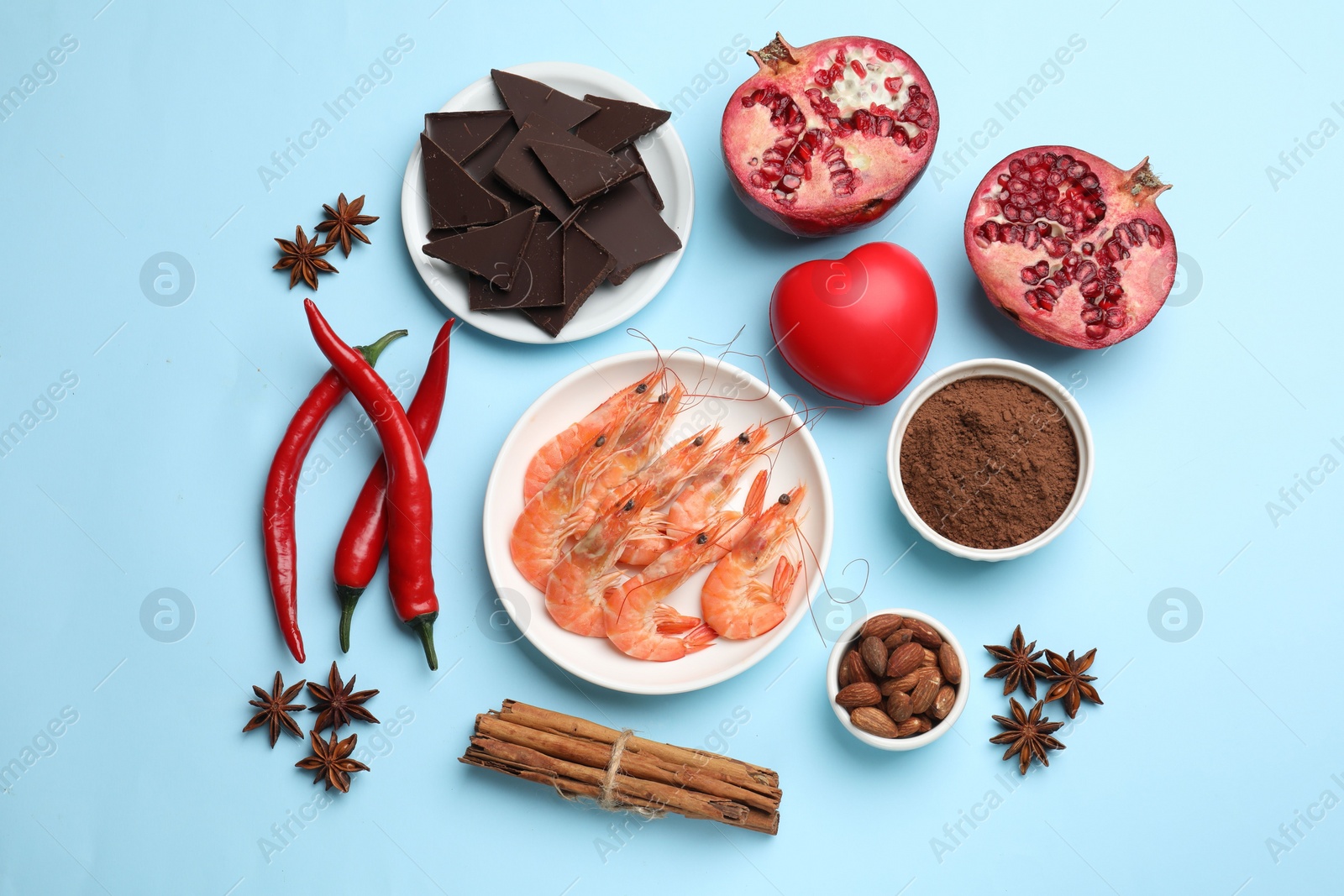 Photo of Natural aphrodisiac. Different products and heart model on light blue background, flat lay