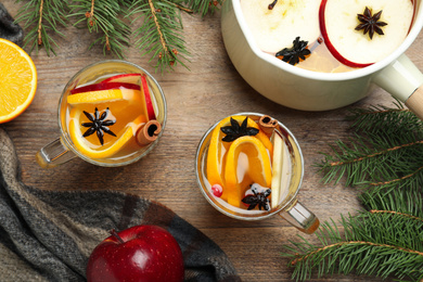 Photo of Aromatic mulled wine on wooden table, flat lay