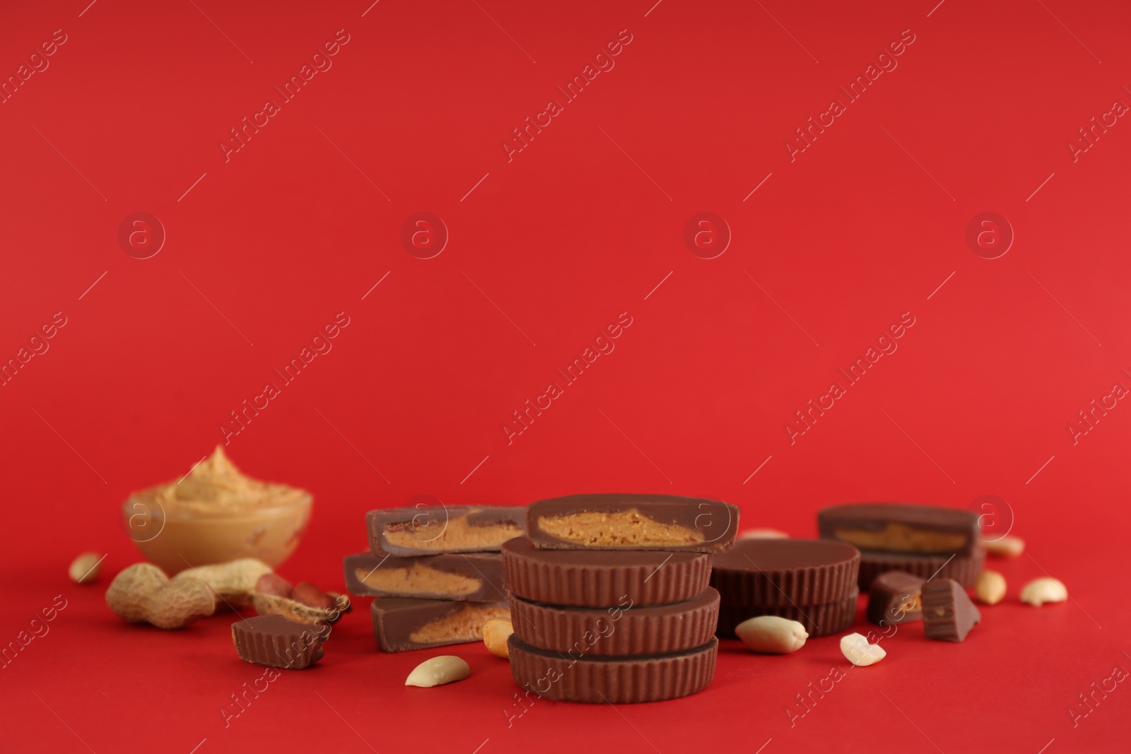 Photo of Sweet peanut butter cups on red background