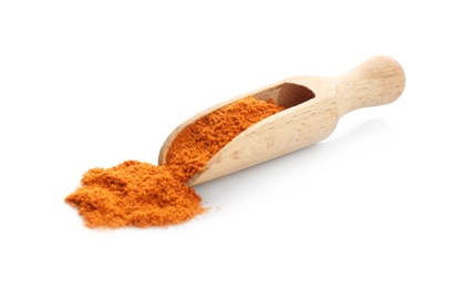 Wooden scoop with red pepper powder on white background