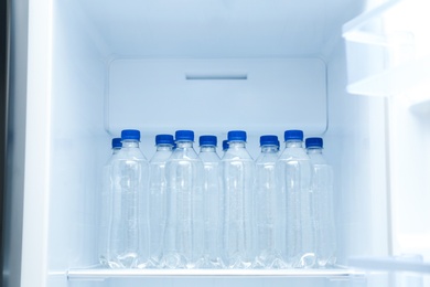 Bottles of pure water on shelf inside refrigerator