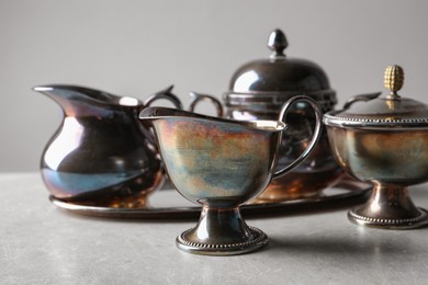 Photo of Beautiful tea set on grey textured table, closeup
