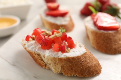 Photo of Delicious ricotta bruschettas with strawberry and mint on plate, closeup