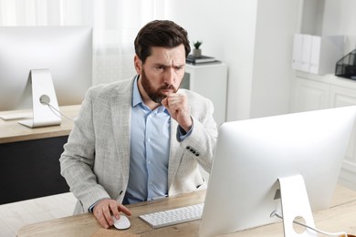 Photo of Sick man coughing at workplace in office. Cold symptoms