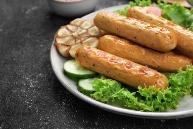 Photo of Delicious grilled vegan sausages on grey table, closeup. Space for text