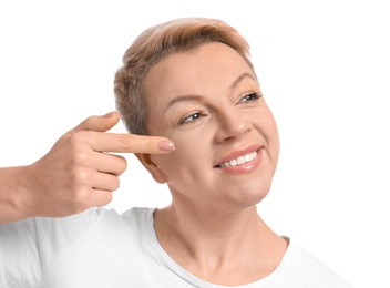 Photo of Mature woman applying face cream on white background