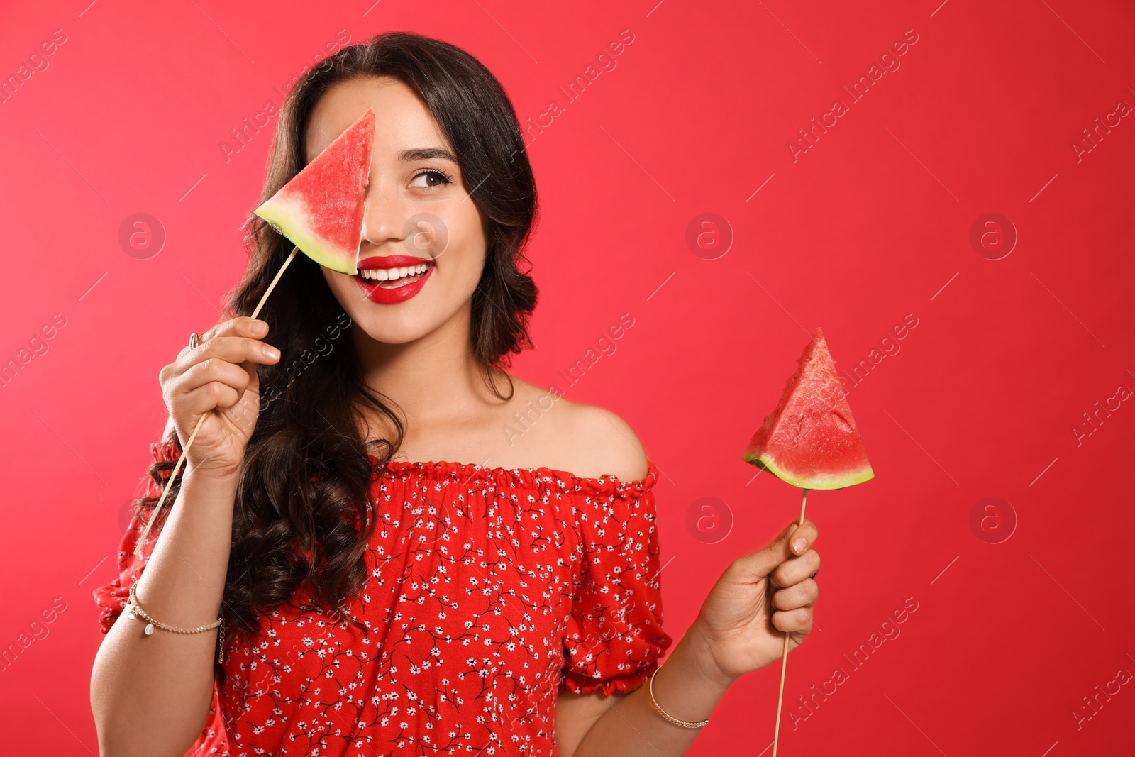 Photo of Beautiful young woman with watermelon on red background