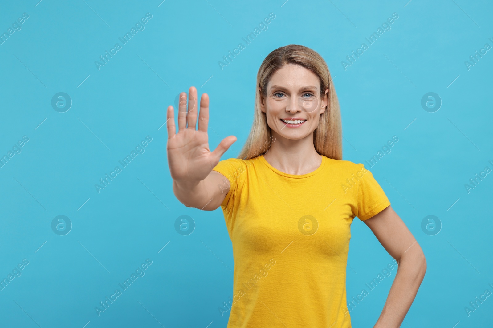 Photo of Woman giving high five on light blue background. Space for text