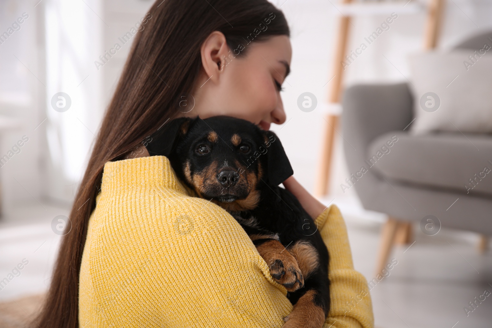 Photo of Woman with cute puppy indoors. Lovely pet