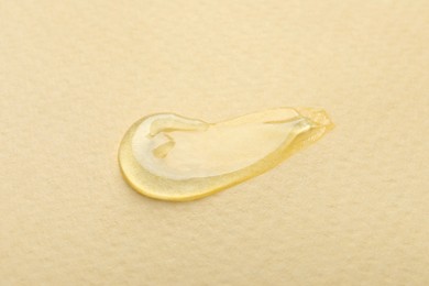 Photo of Sample of transparent gel on yellow background, closeup