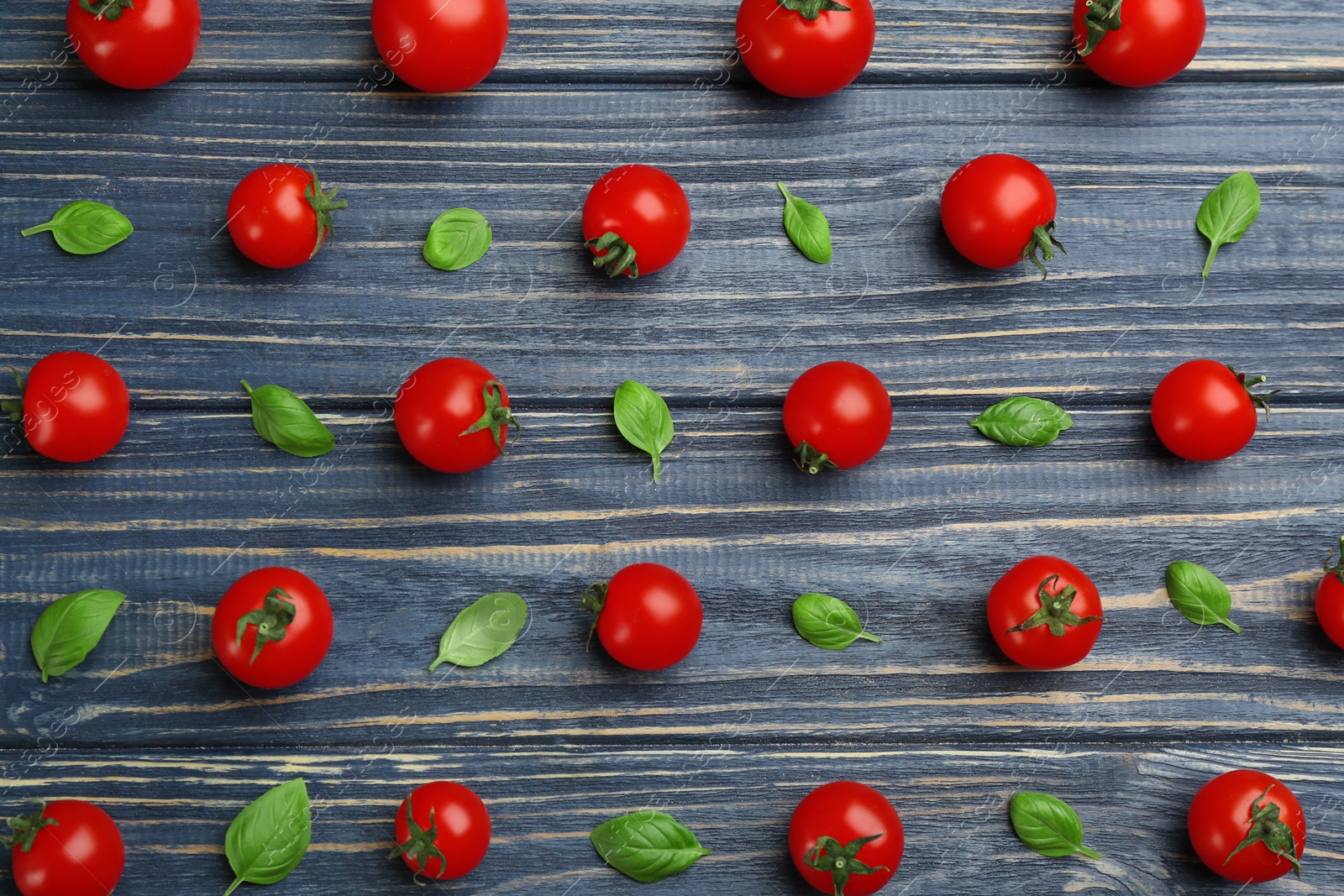 Photo of Flat lay composition with fresh cherry tomatoes and basil leaves on blue wooden table