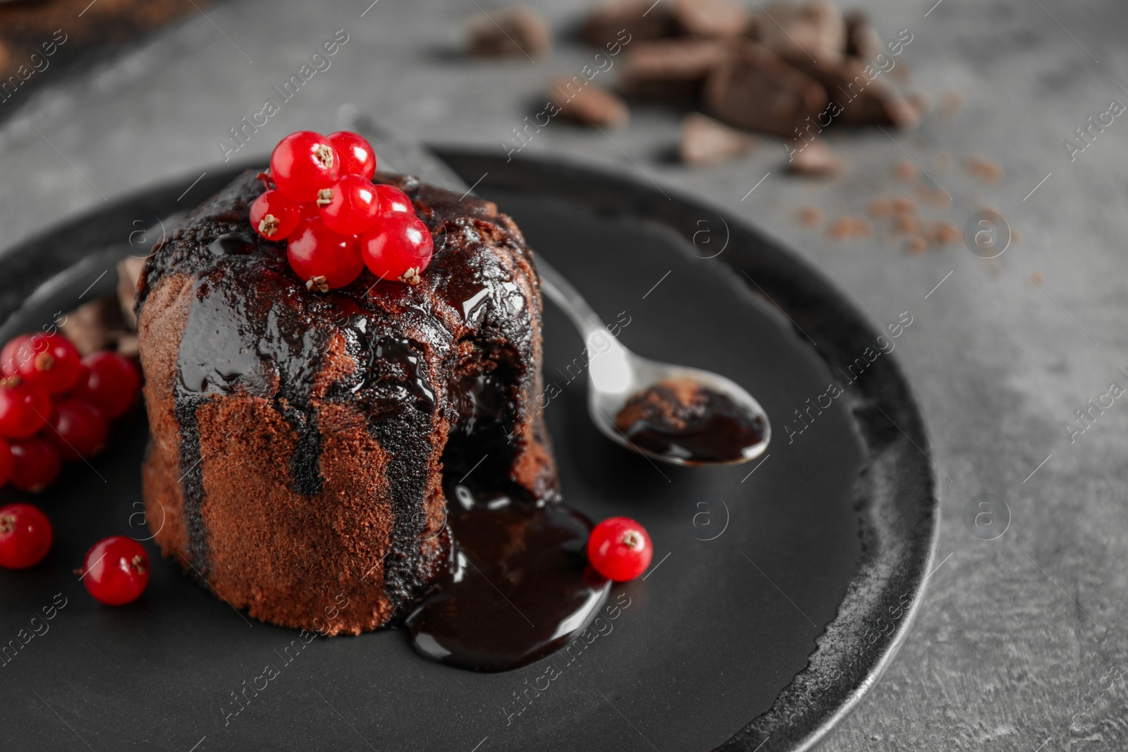 Photo of Delicious warm chocolate lava cake with berries on grey table, closeup