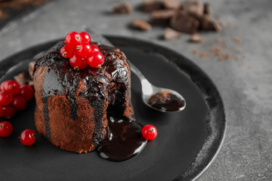 Delicious warm chocolate lava cake with berries on grey table, closeup