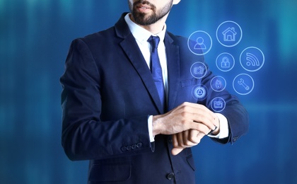 Businessman with modern smartwatch on blue background 