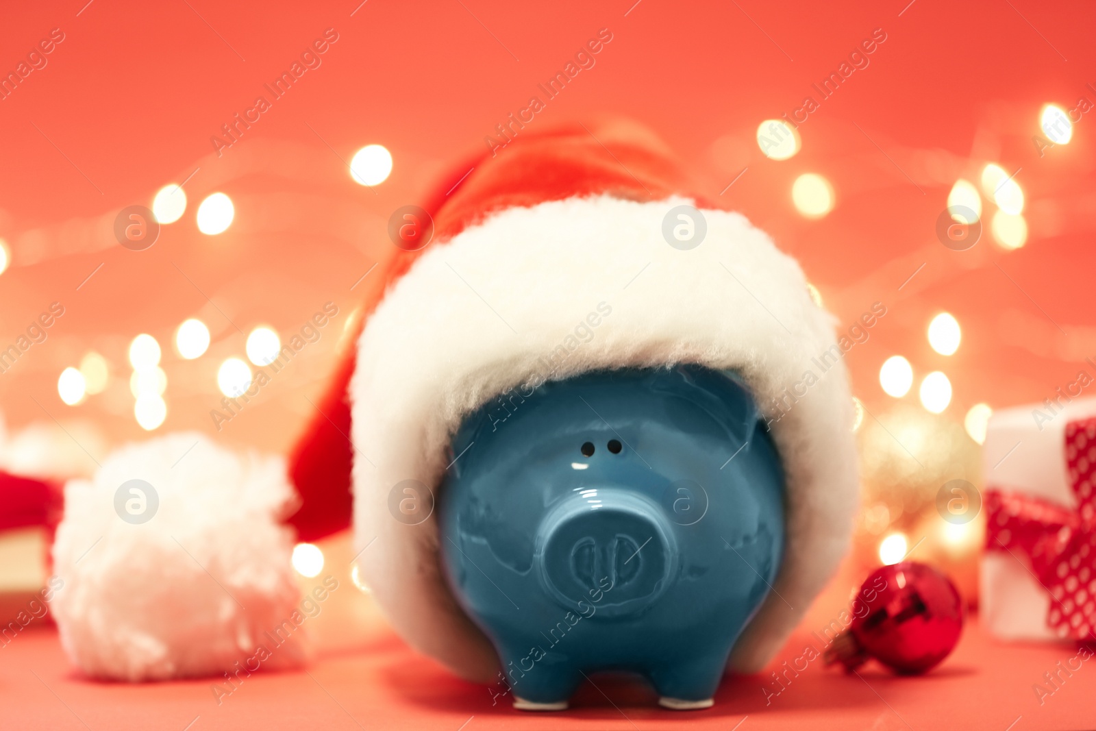 Photo of Piggy bank with Santa hat against blurred background