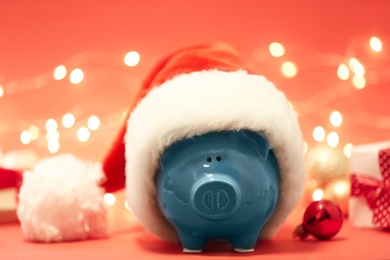 Photo of Piggy bank with Santa hat against blurred background