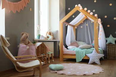 Stylish child room interior with house bed and different toys