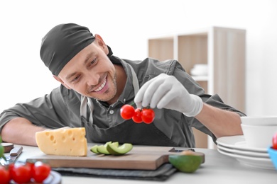 Photo of Professional chef in uniform working at restaurant kitchen