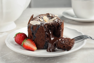 Plate of delicious fresh fondant with hot chocolate and strawberries on table. Lava cake recipe