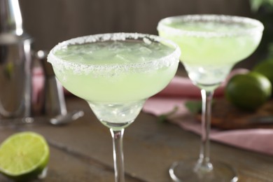 Photo of Delicious Margarita cocktail in glasses on table, closeup