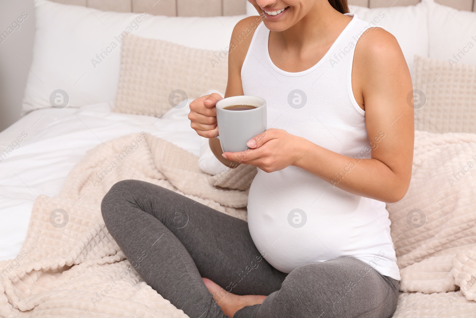 Photo of Pregnant woman drinking tea at home, closeup