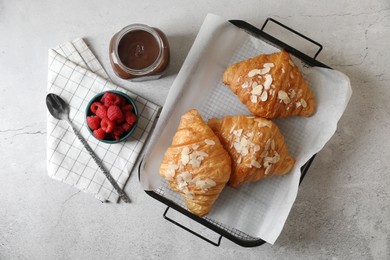 Delicious croissants served on grey table, flat lay