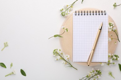 Photo of Guest list. Notebook, pen and beautiful spring tree blossoms on white background, flat lay. Space for text