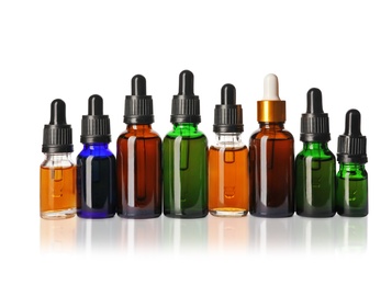 Photo of Cosmetic bottles of essential oils on white background