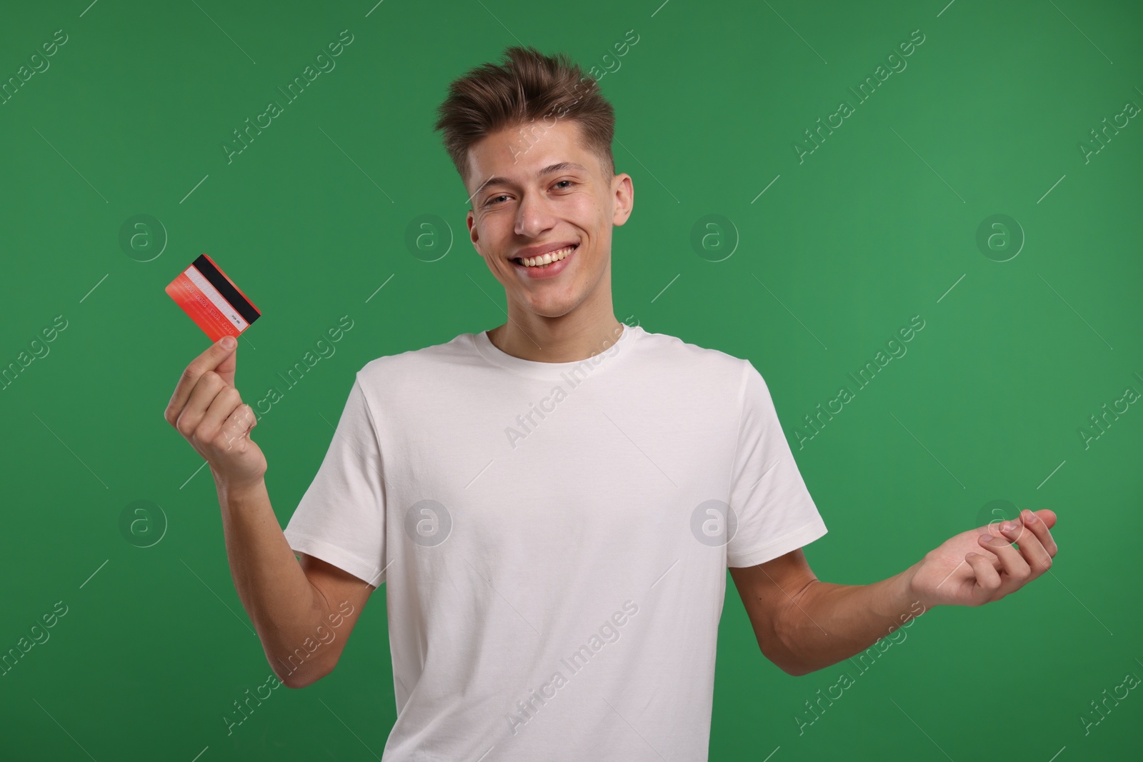 Photo of Happy man with credit card on green background