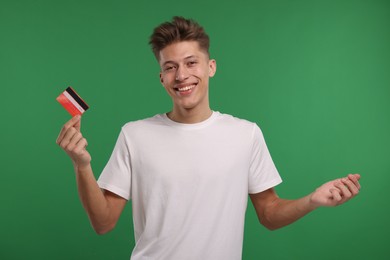 Photo of Happy man with credit card on green background