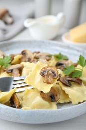 Photo of Delicious ravioli with mushrooms on white table, closeup