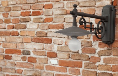 Photo of Vintage street lamp on red brick wall of building