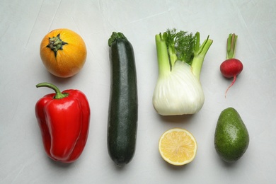 Photo of Flat lay composition with fresh ripe vegetables and fruits on light background
