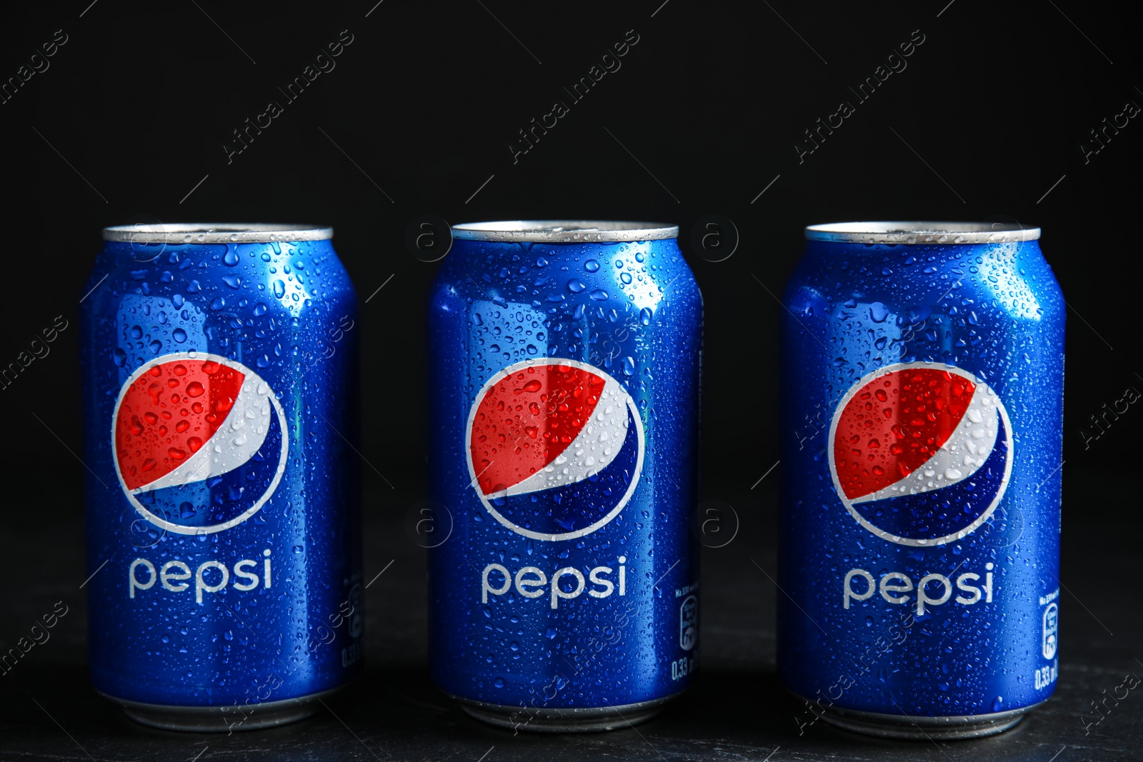 Photo of MYKOLAIV, UKRAINE - FEBRUARY 08, 2021: Cans of Pepsi with water drops on black table
