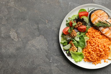 Plate with healthy food high in vegetable fats on grey textured table, top view. Space for text