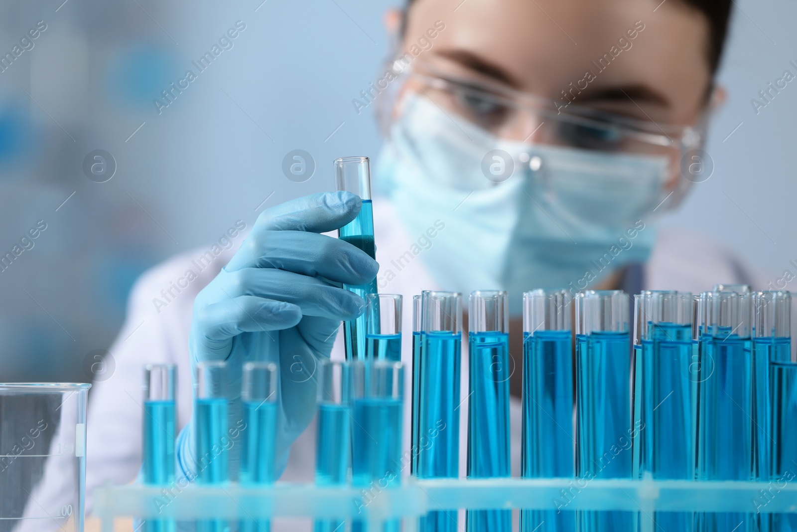 Photo of Scientist holding test tube with sample in laboratory, selective focus
