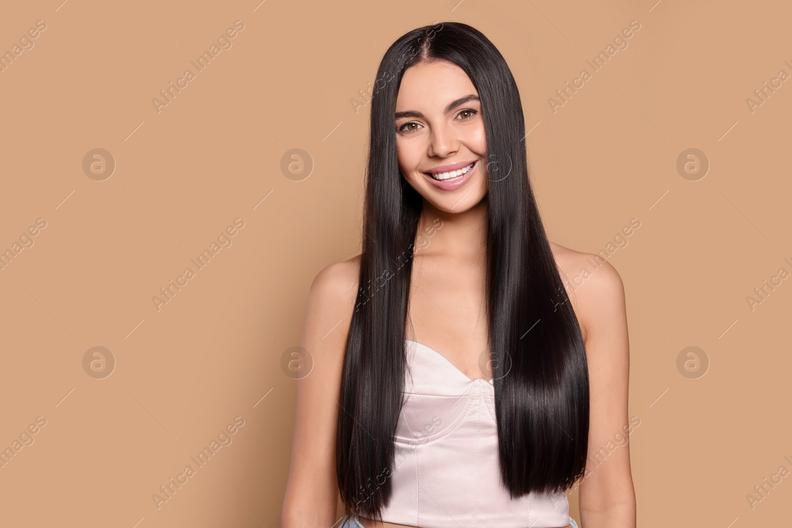 Photo of Portrait of beautiful young woman with healthy strong hair on beige background, space for text