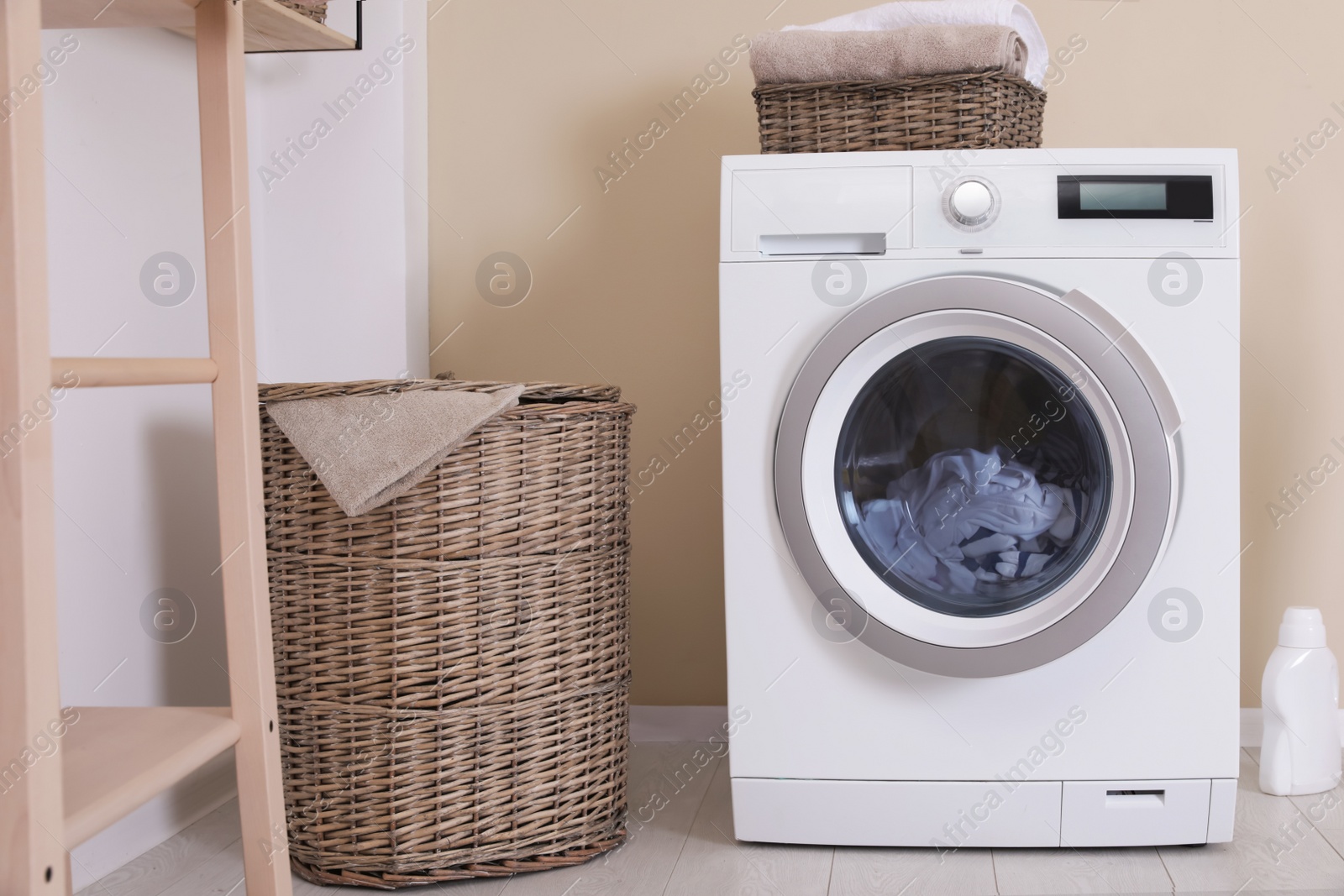 Photo of Laundry room interior with washing machine near wall