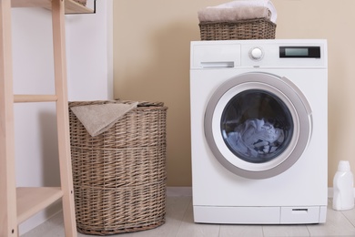 Photo of Laundry room interior with washing machine near wall