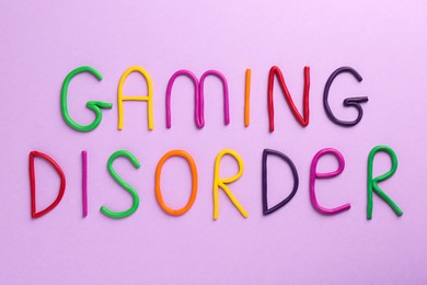 Photo of Phrase Gaming Disorder made of colorful plasticine on violet background, top view