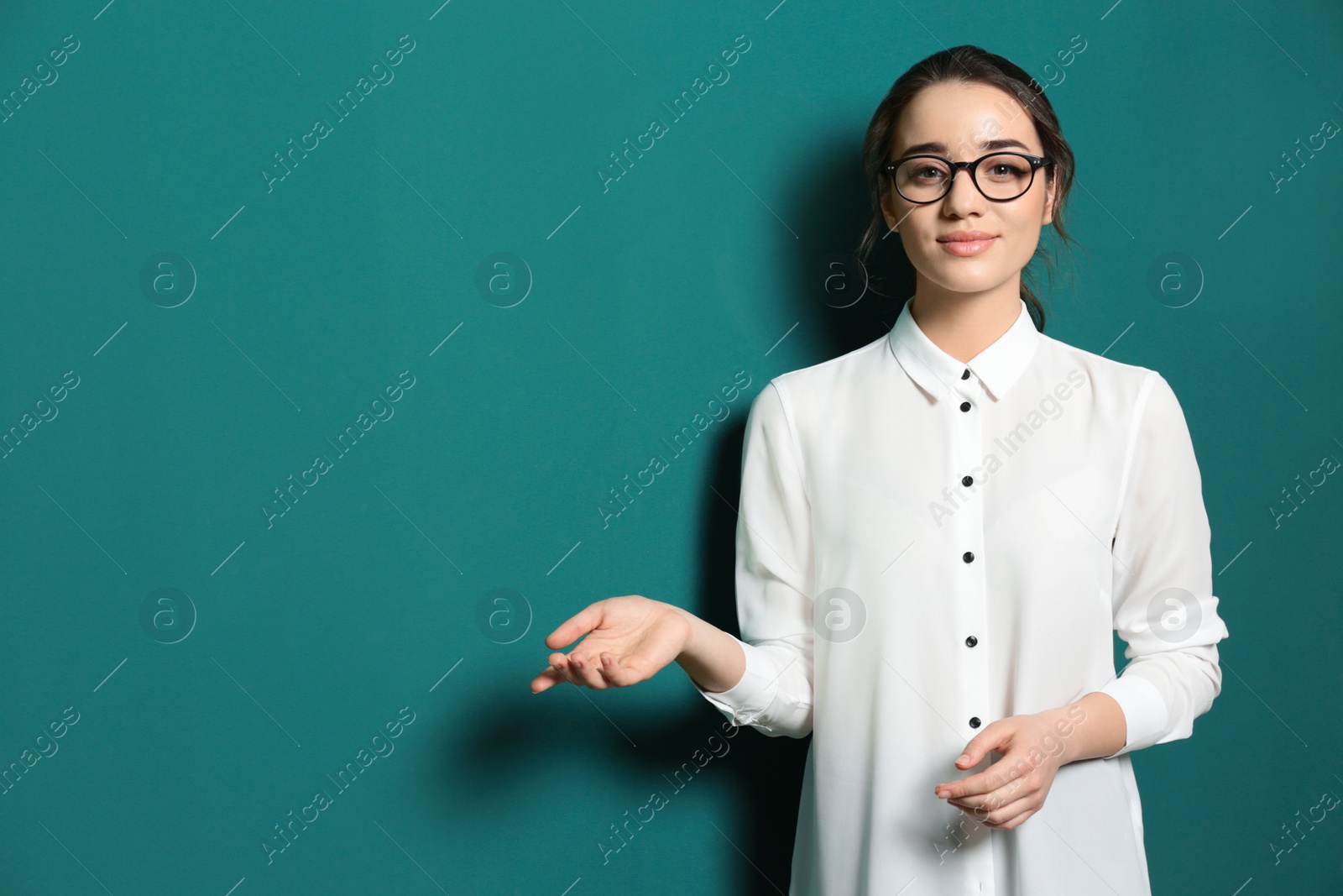 Photo of Portrait of beautiful young teacher near chalkboard, space for text