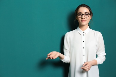 Portrait of beautiful young teacher near chalkboard, space for text